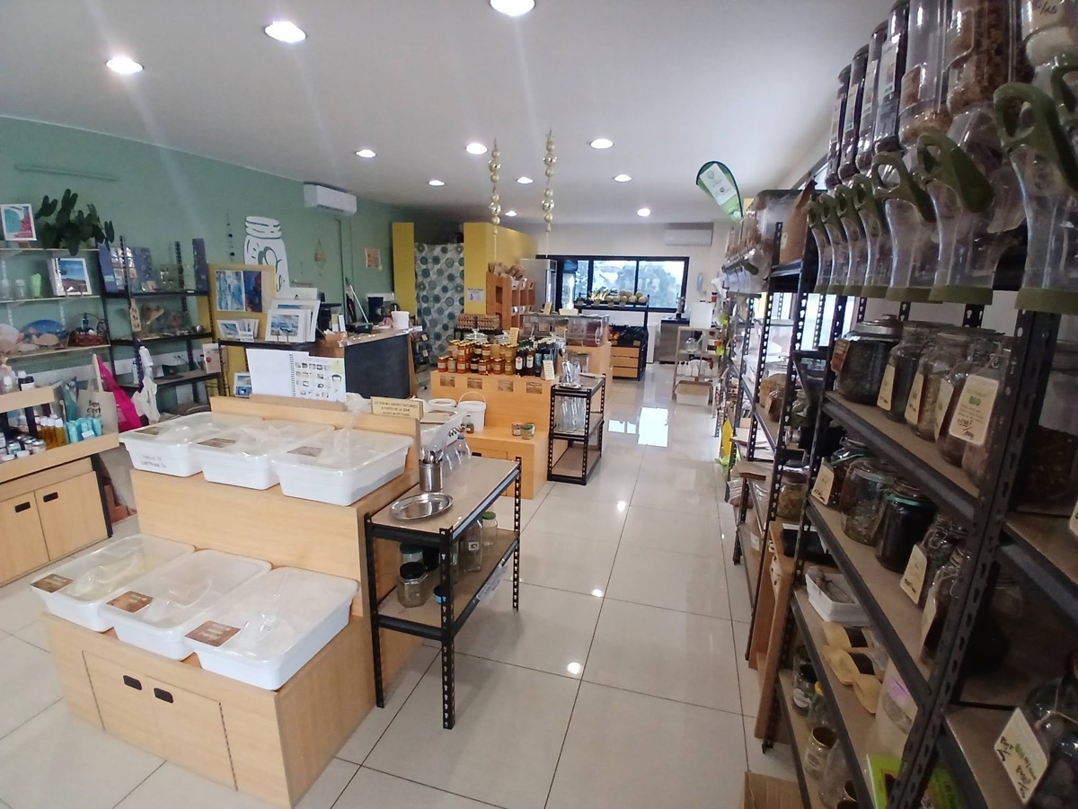 Intérieur de la boutique : rayons de produits en vrac et présentoirs.