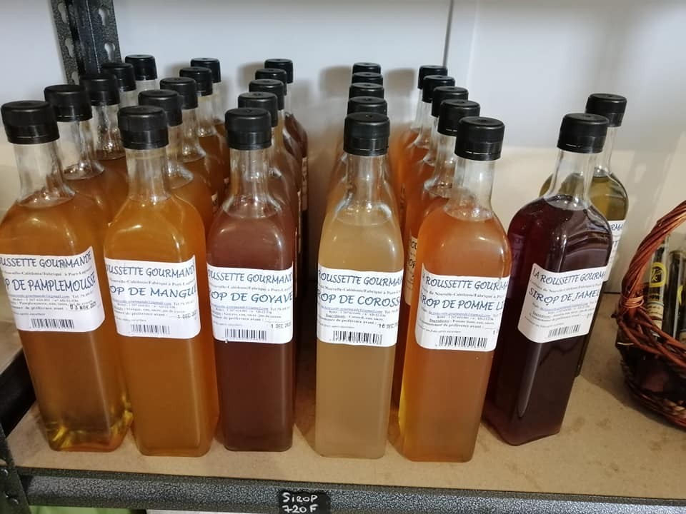 Bouteilles de sirop artisanal alignées sur une étagère.