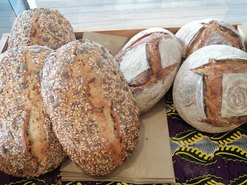 Pains façonnés, aux graines et nature, dans un panier.