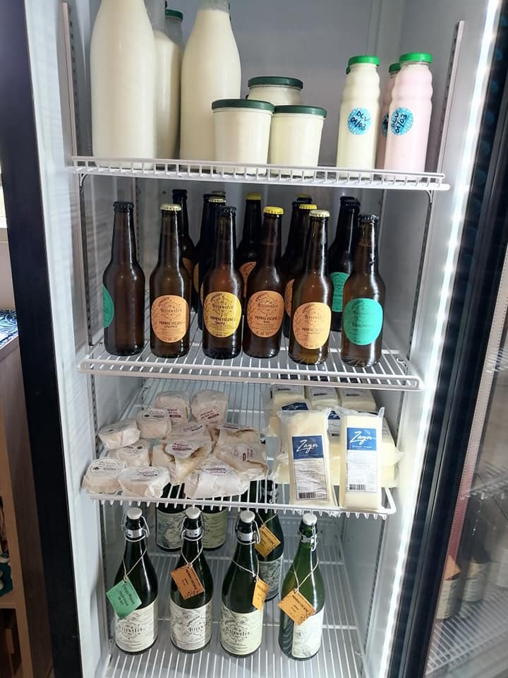 Réfrigérateur avec bouteilles de lait, bières, fromages et boissons.